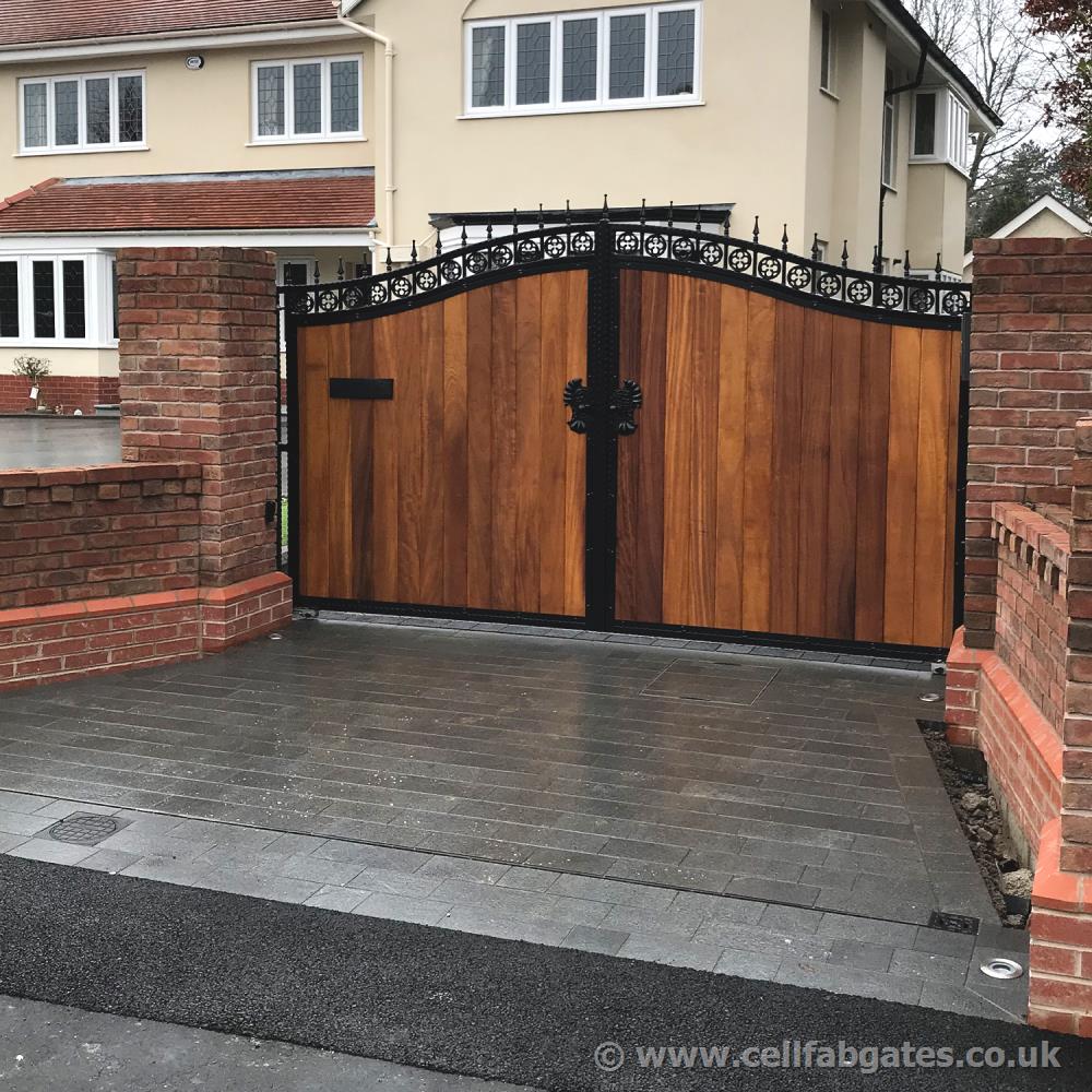 Installation in Manchester of a bespoke, steel frame, timber infill driveway gate with a custom ornate iron letter box.
