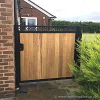 A bespoke timber infill gate, with ornate features and a lock and key, installed in Burscough, Lancashire.
