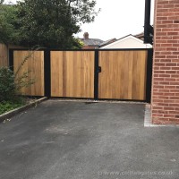 A flat top, timber infill driveway gate created with matching side panels and installed at a property in Croston.