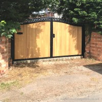 A steel and wood infill driveway gate, created with a bespoke iron letter box and fitted in Wolverhampton.